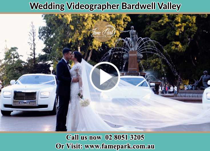 The newlyweds kissing near the wedding car Bardwell Valley NSW 2207